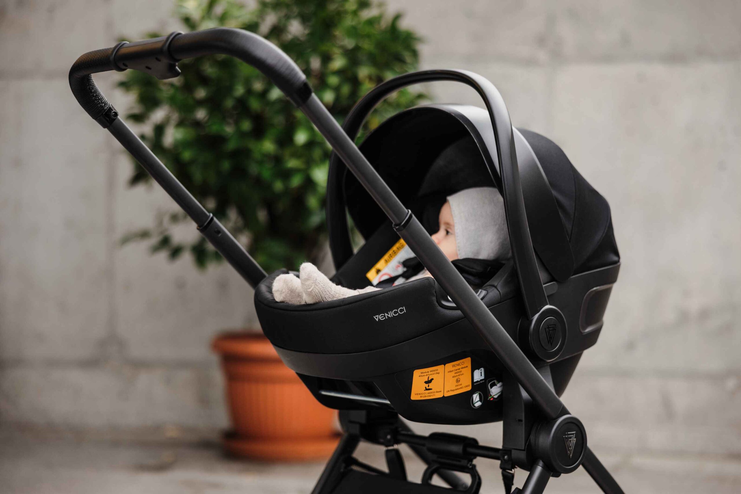 Child in car seat in pram