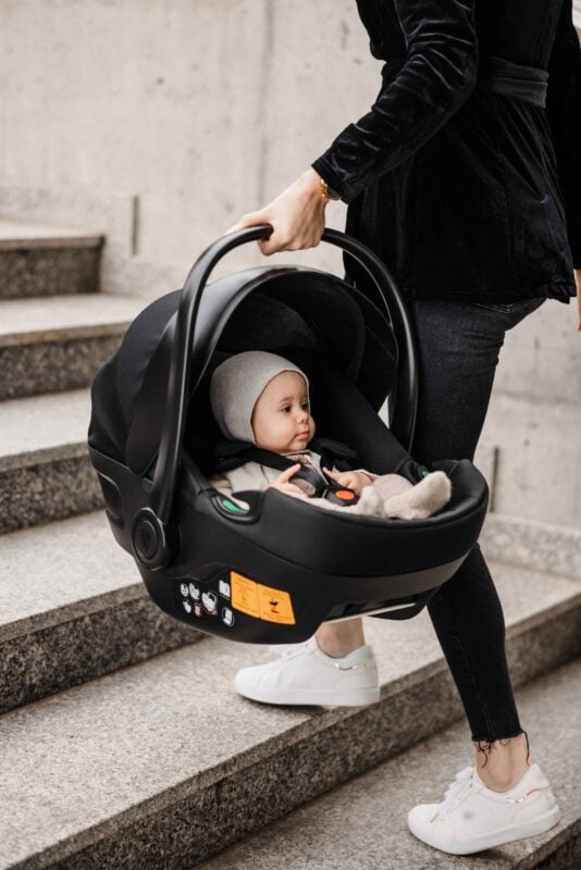 Child in car seat on stairs